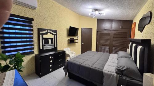 a bedroom with a bed and a dresser and a mirror at Casa Luna in Ciudad Madero