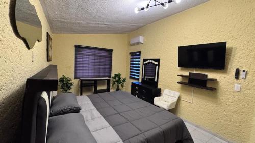 a bedroom with a bed and a flat screen tv at Casa Luna in Ciudad Madero