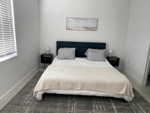 a bedroom with a large bed with a blue headboard at Beautiful 3 bed 2 bath pool & lake view 10 min from beaches in Englewood