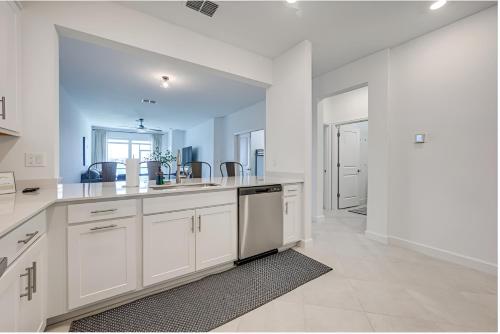 a kitchen with white cabinets and a large mirror at Beautiful 3 bed 2 bath pool & lake view 10 min from beaches in Englewood