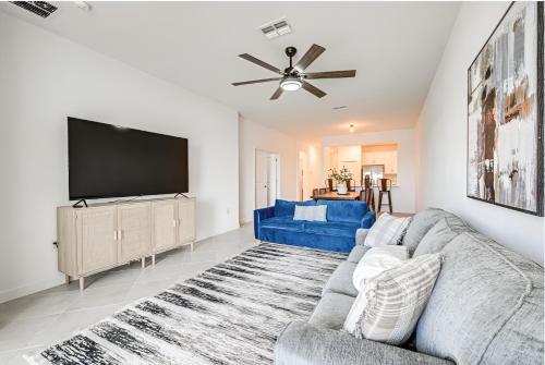 a living room with a blue couch and a flat screen tv at Beautiful 3 bed 2 bath pool & lake view 10 min from beaches in Englewood