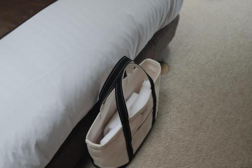 a purse sitting on the side of a bed at Law Firm ローファーム in Nagano