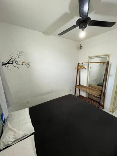 a room with a bed and a ceiling fan at WATERMAN Surf Camp Hospedagem e Escola de Surf, Kitesurf, SUP em Florianópolis in Florianópolis