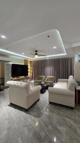 a living room with two white couches and a television at One Euphoria Luxe Hotel in Angeles