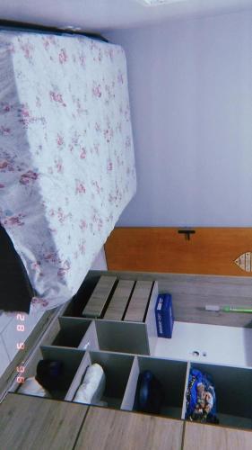 a room with a bed with boxes on the floor at Apartamento Mobiliado in Guaíba