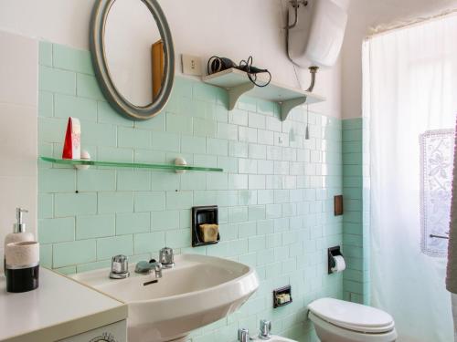 a bathroom with a sink and a mirror and a toilet at Holiday Home in Liguria near Barbottina Forest in Calizzano