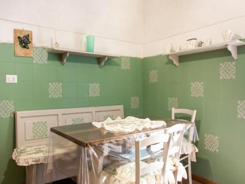a kitchen with green walls and a table and chairs at Holiday Home in Liguria near Barbottina Forest in Calizzano