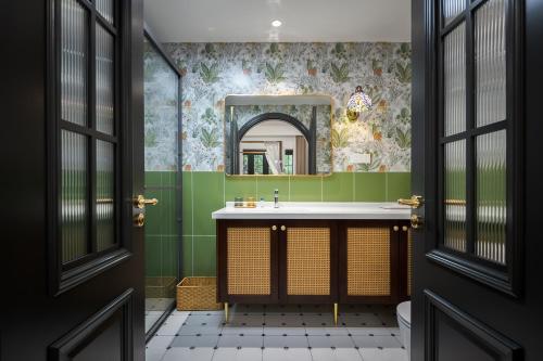 a bathroom with green walls and a sink and a mirror at Luxury Riverside House with Garden in Central Suzhou in Suzhou
