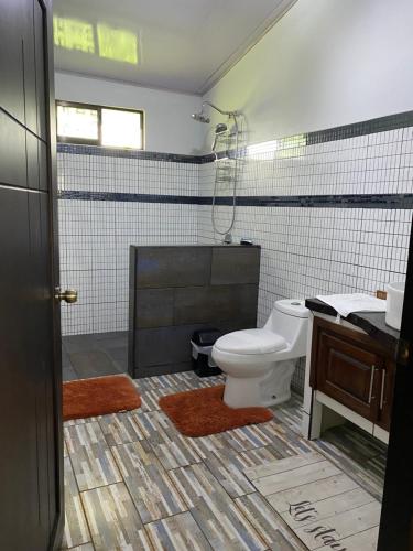 a bathroom with a toilet and a sink at Villa Fortuna, Villa & Piscina, Volcán Arenal in Guayabal