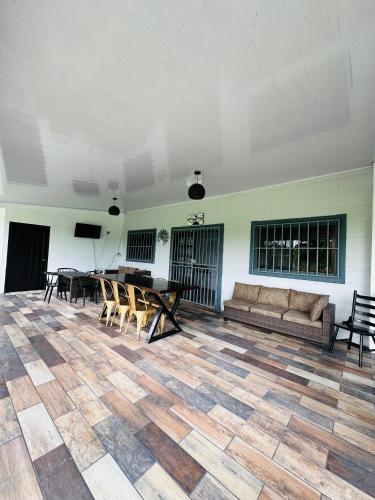 a living room with a couch and a table and chairs at Villa Fortuna, Villa & Piscina, Volcán Arenal in Guayabal