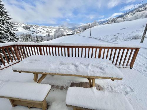 a picnic table covered in snow on a deck at Chalet indépendant avec spa, sauna et cheminée à Notre-Dame-de-Bellecombe - 10 pers - FR-1-595-102 in Notre-Dame-de-Bellecombe