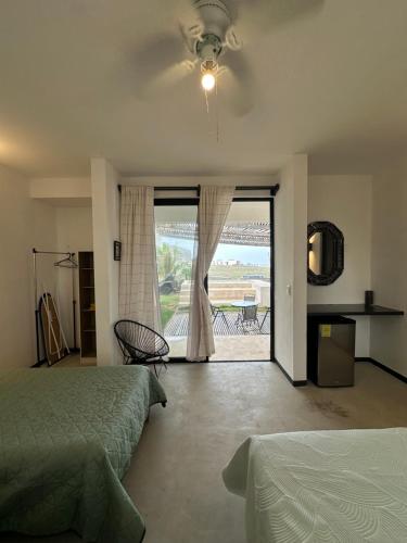 a bedroom with a bed and a sliding glass door at Punta Conejo Camila bungalows Surf Camp in Reparo
