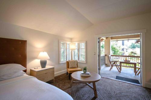 a bedroom with a bed and a table and a patio at Appellation Lodi - Wine & Roses Resort and Spa in Lodi