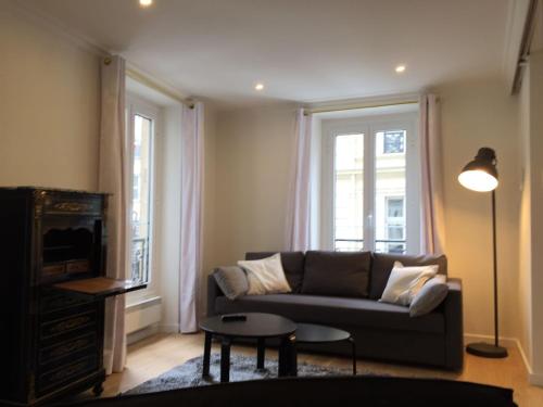 a living room with a couch and a tv at Bellechasse Apartments in Paris