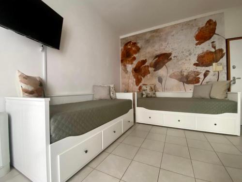 a bedroom with two beds and a tv at Casa Noè - cozy home with big terrace and private box in Turin