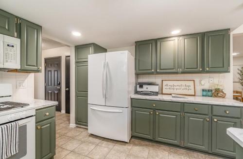 a kitchen with green cabinets and a white refrigerator at Large Group, Family, Bachelorette Parties, Handicap Accessible, Long Term Stays Welcome in Bay City