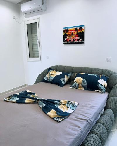 a bed with a blanket on top of it at Villa roche in Awlād ‘Umar