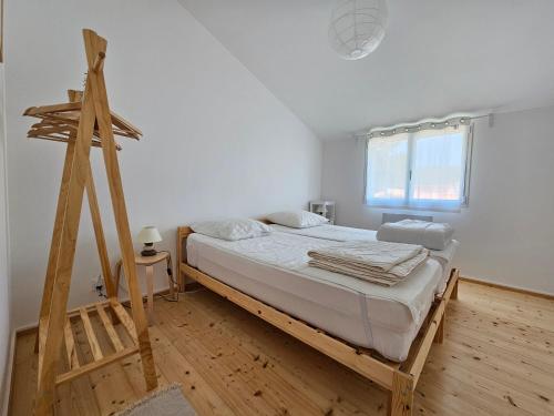 une chambre avec un lit et une échelle en bois dans l'établissement Jolie Villa à 120m Plage - 4 Pers - La Faute-sur-Mer - FR-1-476-233, à La Faute-sur-Mer
