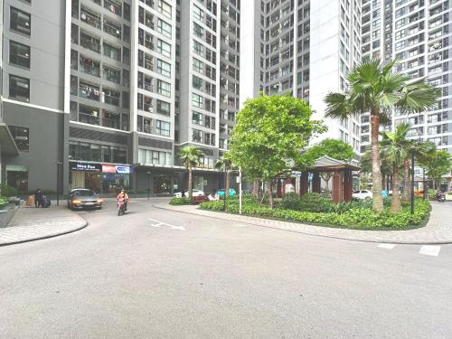 a person riding a motorcycle down a street with tall buildings at Delux Stu Apt In Vinhomes, Close to JW Marriott, Keangnam and My Dinh in Hanoi