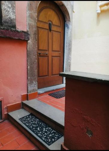 a wooden door on a building with a staircase at La Casa di Gioia in Tuscania