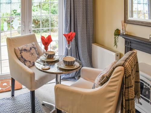 a living room with a table and chairs and a fireplace at Sam's Snug in Birchington