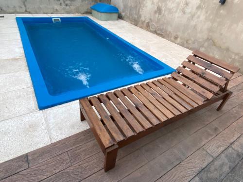 a wooden bench sitting next to a swimming pool at Alquiler Temporario Las Parejas in Las Parejas