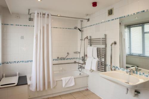 a white bathroom with a tub and a sink at Holiday Inn York by IHG in York