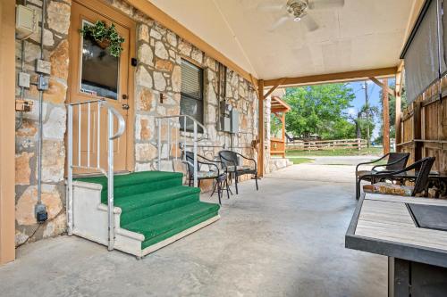 a stone house with a green porch with chairs at The Lazy Spur in Bandera