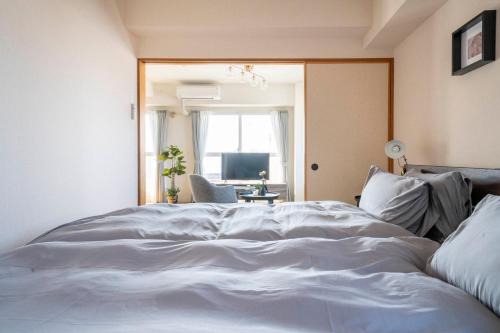 a large white bed in a room with a window at E-US Naebo 603 in Sapporo