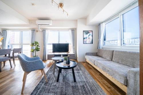 a living room with a couch and a tv at E-US Naebo 603 in Sapporo