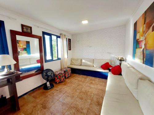 - un salon avec un canapé blanc et une fenêtre dans l'établissement Casa Espaçosa 6 Qts Churrasqueira 10 min Praia do Forte, à Cabo Frio