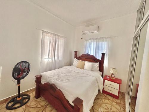 a bedroom with a large bed and a fan at Villa Rosa 3 Habitaciones Balcones Aire Acondicionado Espacio Ideal Para Tu Familia O Grupo in Río San Juan