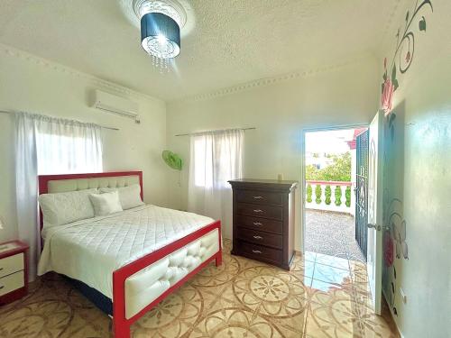 a bedroom with a bed and a dresser and a window at Villa Rosa 3 Habitaciones Balcones Aire Acondicionado Espacio Ideal Para Tu Familia O Grupo in Río San Juan
