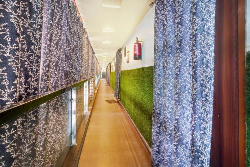 a hallway with blue curtains and green walls at Super Hotel O Grill Inn in Dhanbād