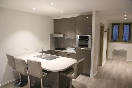 une cuisine avec une table et des chaises dans une pièce dans l'établissement Les Dentelles - Appartement meublé design Petite France, à Strasbourg