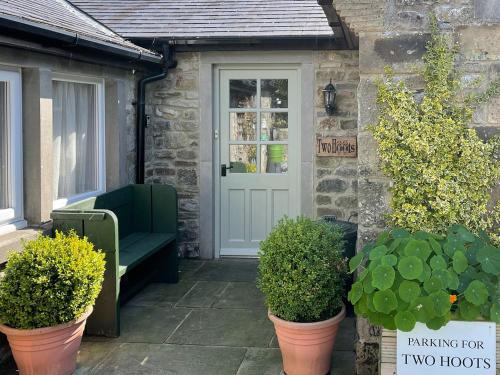 a front door of a house with two plants at Two Hoots in Wigglesworth