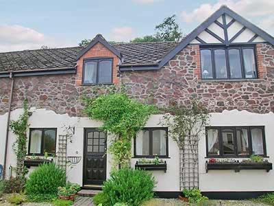 a brick house with black doors and windows at Dove Cottage in Minehead