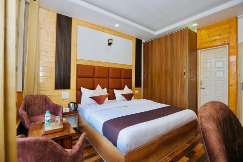 a bedroom with a large bed and two chairs at Verma Homestay by Decent stays in Shimla