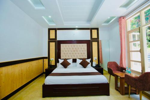 a hotel room with a bed and a table and chairs at Nature Retreat new shimla #city centre #near to mall road #private parking #Balcony view in Shimla