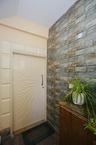 a brick wall with a garage door and plants at Verma Homestay by Decent stays in Shimla