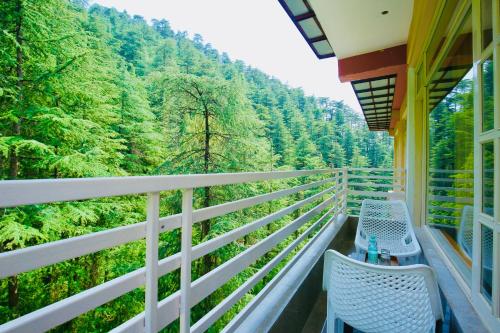 a balcony with two chairs and a view of a forest at Nature Retreat new shimla #city centre #near to mall road #private parking #Balcony view in Shimla
