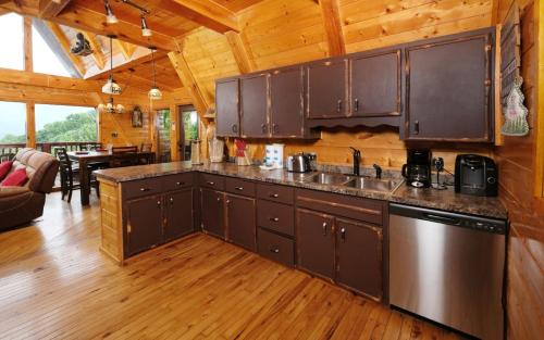 a kitchen with brown cabinets and a living room at Bear Mountain Retreat in Gatlinburg