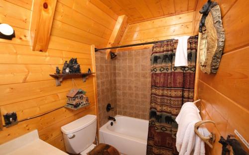a bathroom with a toilet and a shower in a log cabin at Bear Mountain Retreat in Gatlinburg