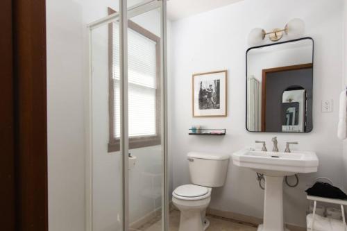 Un baño con inodoro, lavabo y espejo. en LumberJill Lodge Room 3, en Balsam Lake