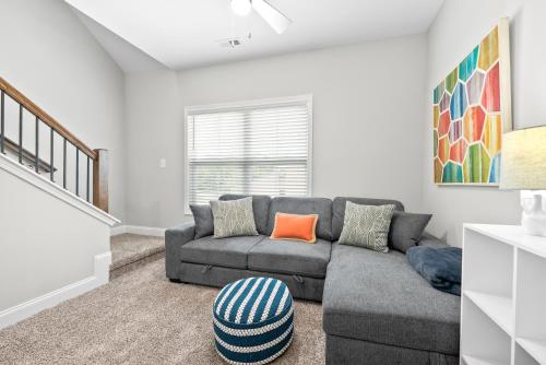 a living room with a gray couch and orange pillows at Whole Home 1012 & 1014 Franklin in Clarksville