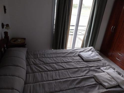 a bed with two pillows on it in front of a window at LoDeLira Apart in Federación
