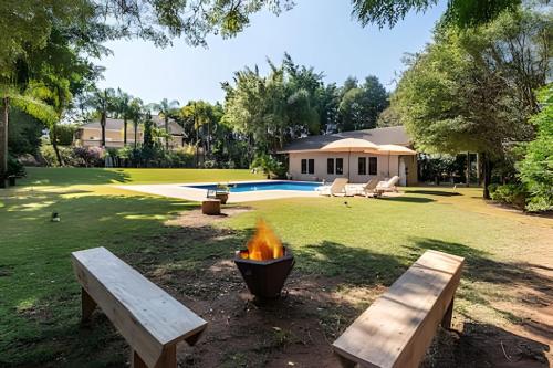 a fire pit in a yard with two benches at Condomínio Vila Real - Villa de Luxo com Piscina in Itu