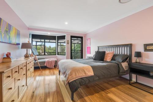 a bedroom with a bed and a desk and a television at 13 AMAROO in Port Macquarie