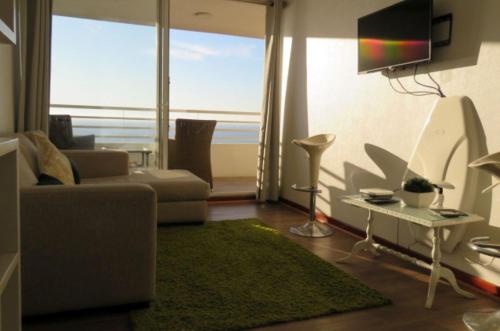 a living room with a couch and a green rug at Vista y Mar in Valparaíso