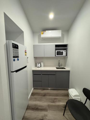 a small kitchen with a refrigerator and a sink at Hay Caravan Park in Hay